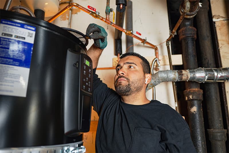 Contractor inspecting heat pump water heater