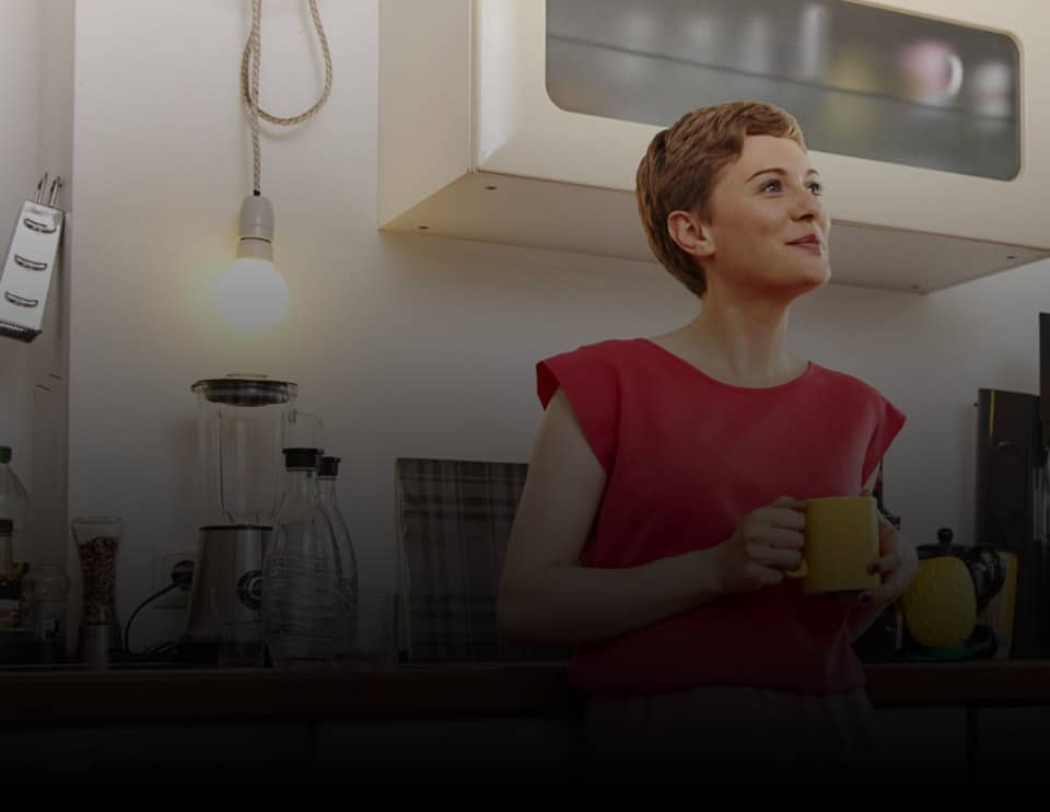 Woman drinking coffee while standing in the kitchen